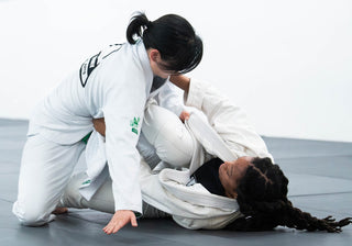 Two students in gis working a live BJJ round at One Way Martial Arts in Alexandria, VA