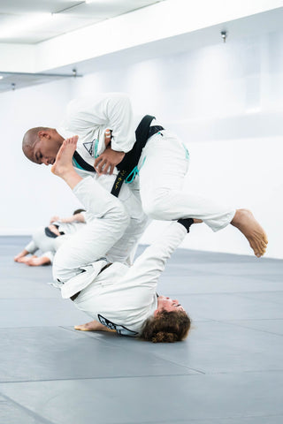 BJJ students drilling a sweep in the gi at One Way Martial Arts in Alexandria, VA