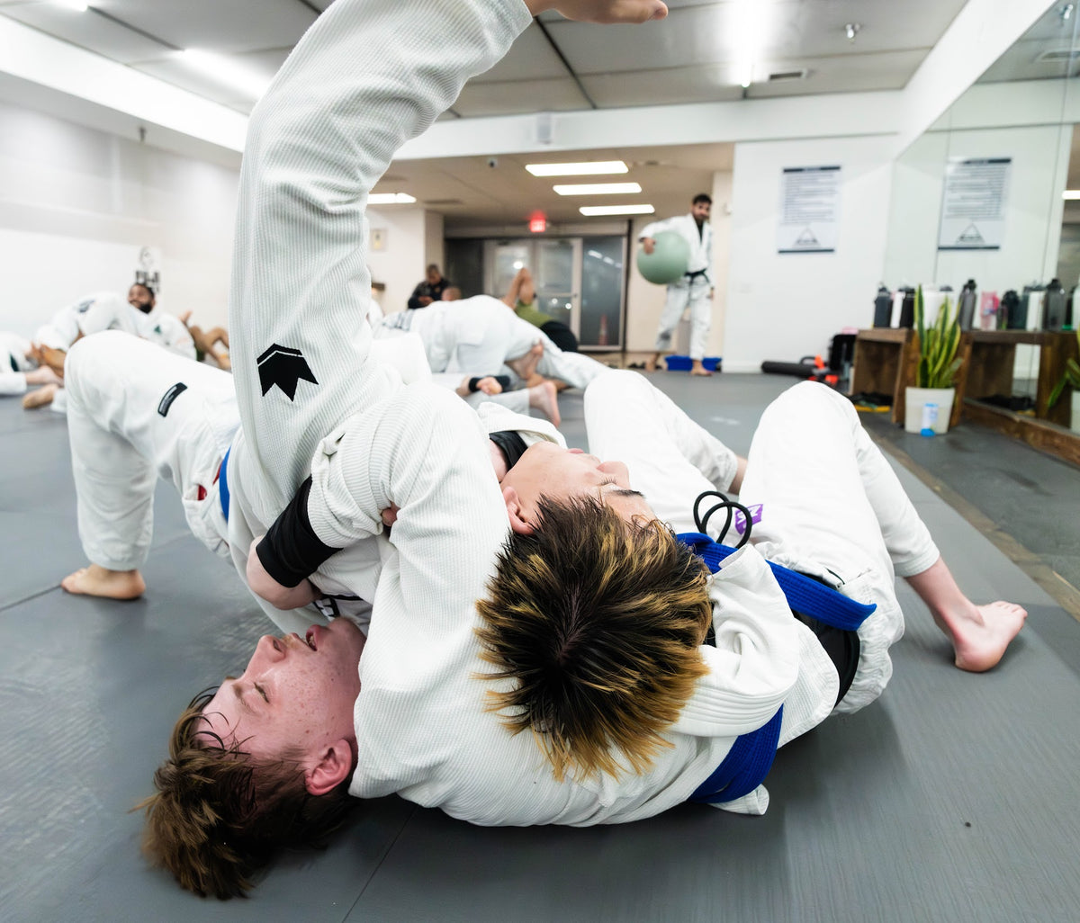 BJJ students rolling in a busy gi class at One Way Martial Arts in Alexandria, VA