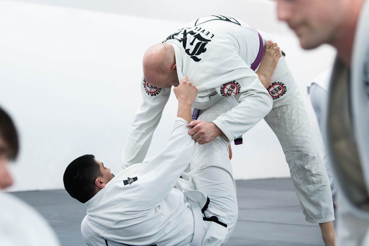 BJJ students drilling a guard pass in the gi at One Way Martial Arts in Alexandria, VA