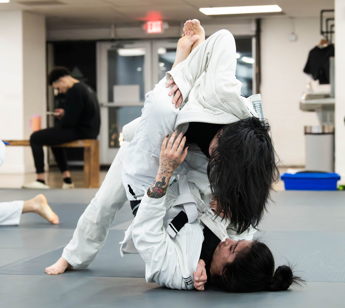 Women drilling closed guard in a gi BJJ class at One Way Martial Arts in Alexandria, VA