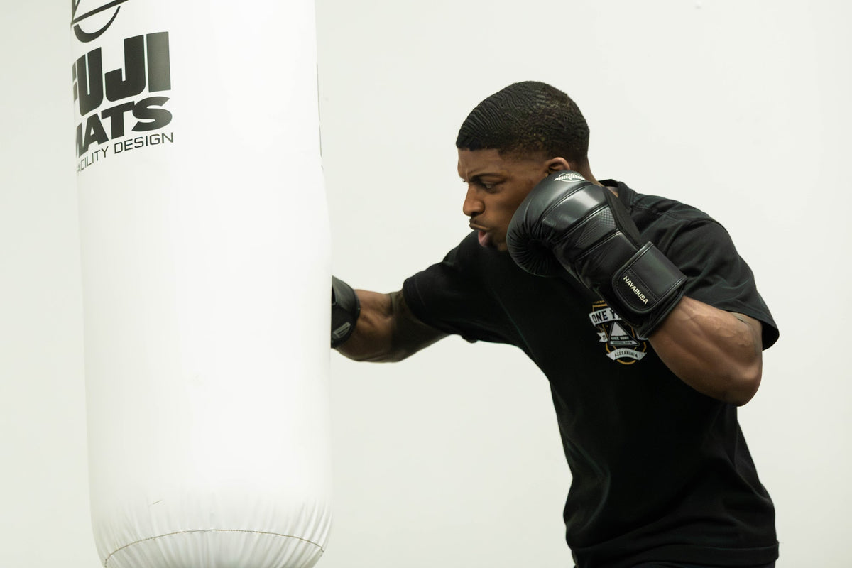 Student punching the heavy bag in boxing class at One Way Martial Arts in Alexandria, VA