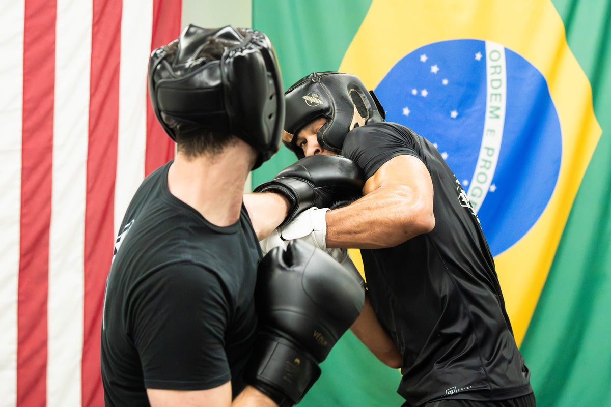 Two students sparring in headgear in boxing class at One Way Martial Arts in Alexandria, VA