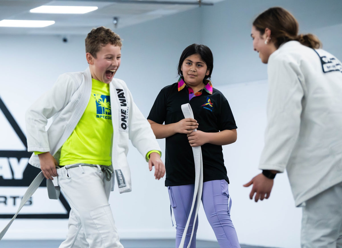 Kids laughing with their coach during Kids BJJ class at One Way Martial Arts in Alexandria, VA