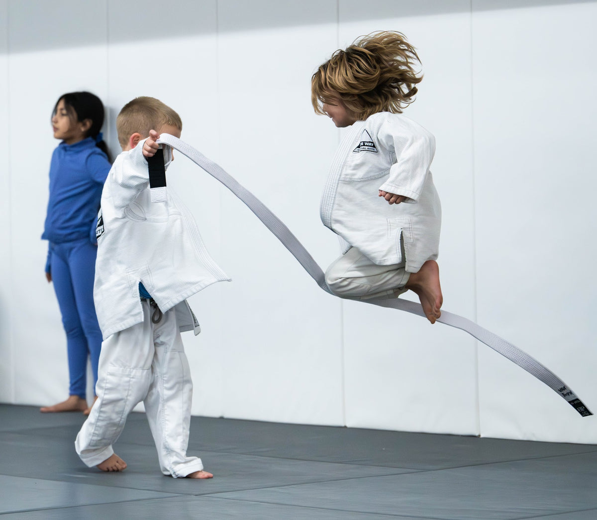 Young children playing a belt jumping game in Tots BJJ at One Way Martial Arts in Alexandria, VA