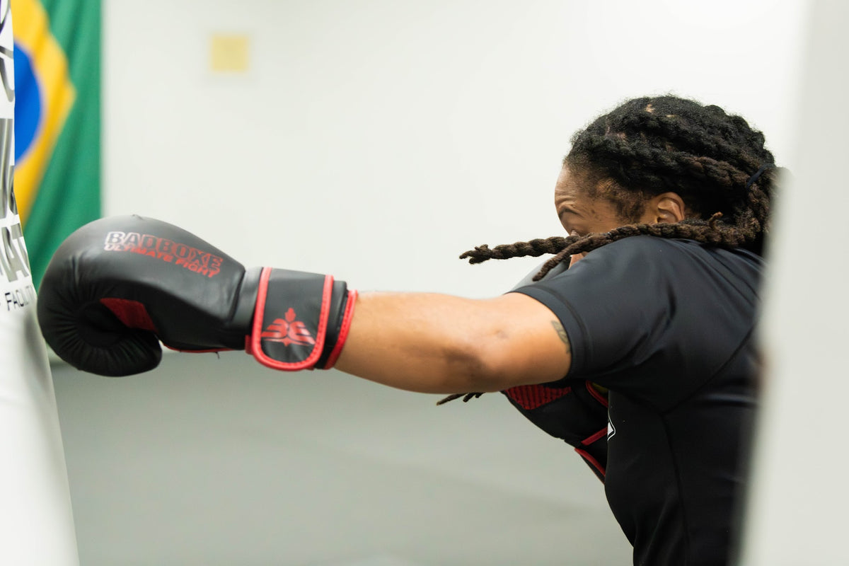 Woman throwing a punch in boxing gloves during class at One Way Martial Arts in Alexandria, VA